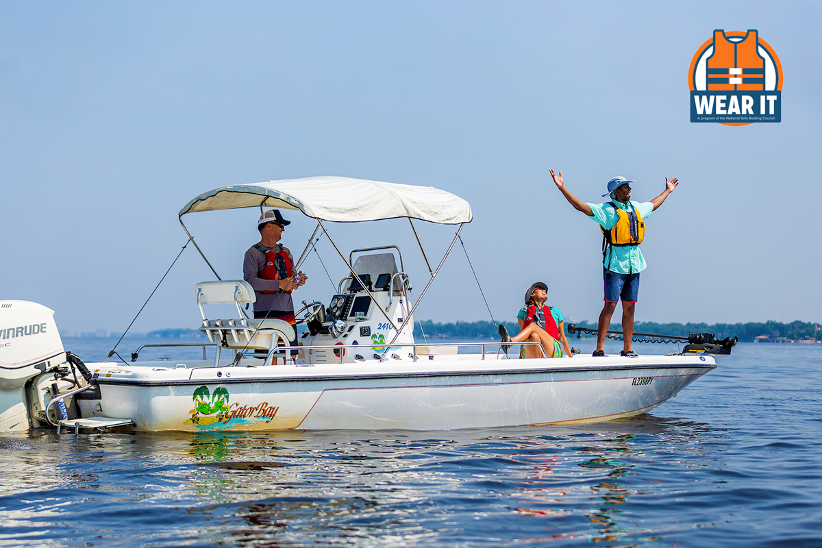 Three people in a boat on the water wearing life jackets